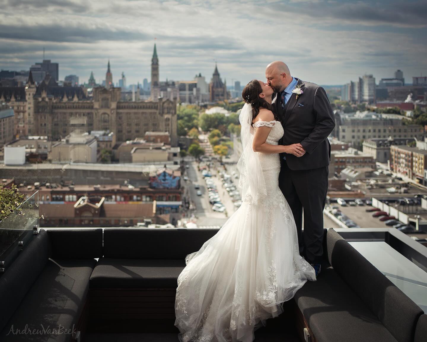 Bridge & Groom, kissing on the rooftop of the Andaz Hotel, with the Byward Market and Parliament Hill beyond.